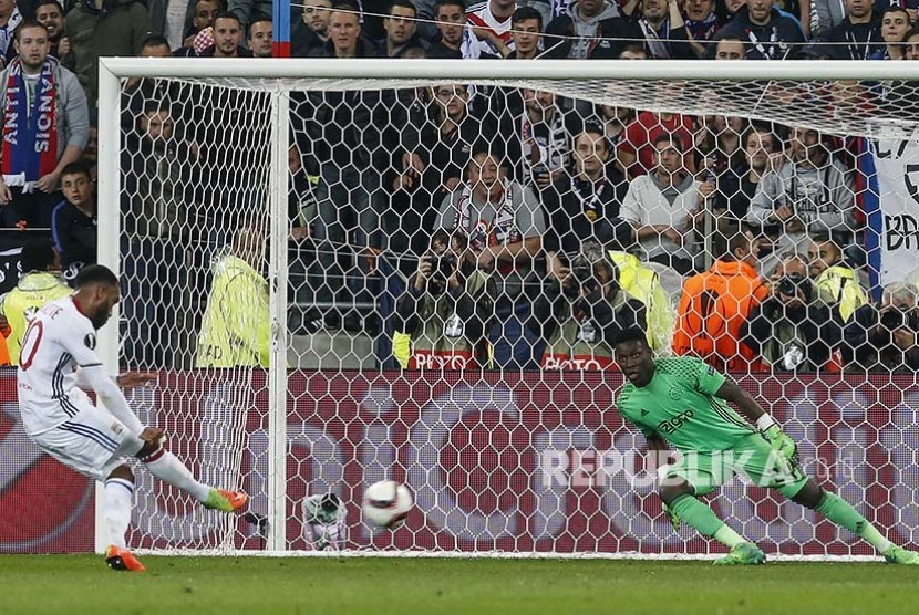 Pemain Lyon Alexandre Lacazette mencetak gol dari titik penalti  ke gawang yang dijaga Andre Onana (kanan)  dalam pertandingan semifinal Europa League di Stadion Old Trafford, Jumat (12/5) dini hari.