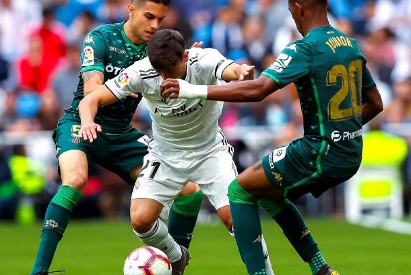 Pemain Madrid berebut bola dengan pemain Real Betis dalam pertandingan di Santiago Bernabeu, Ahad (20/5).