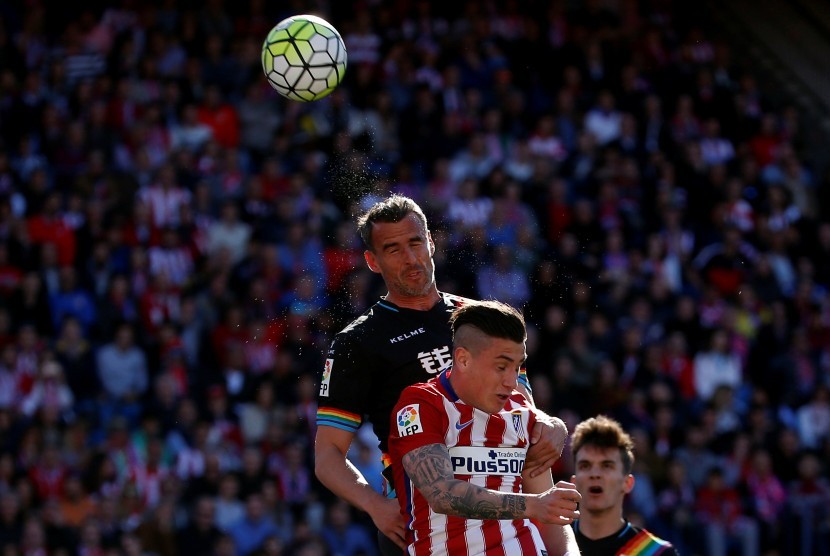 Pemain Madrid Jose Maria Gimenez beradu dengan pemain Rayo Vallecano Antonio Amaya, Sabtu (1/5).