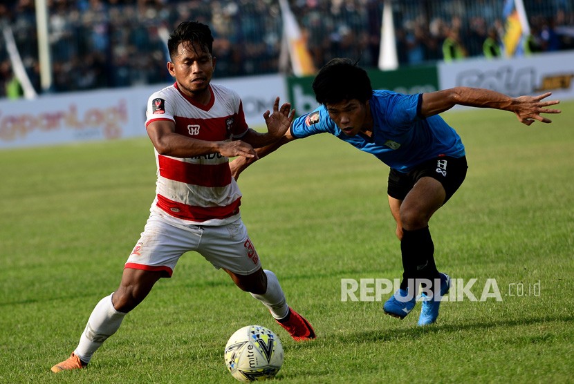 Pemain Madura United Andik Vermansah (kiri) berebut bola dengan pemain Persela Kei Hirose dalam pertandingan babak delapan besar Piala Presiden 2019 di Stadion Surajaya Lamongan, Jawa Timur, Ahad (31/3/2019).