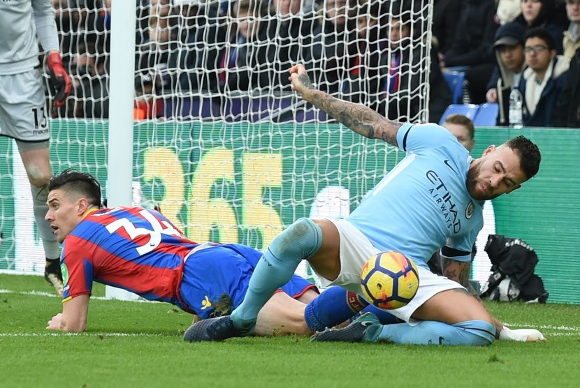 Pemain Manchester City Nicolas Otamendi (kanan) berebut bola dengan pemain Crystal Palace Martin Kelly (kiri) pada lanjutan Liga Primer 2017/2018 di Selhurst Park, London, Inggris, Ahad (31/12). 