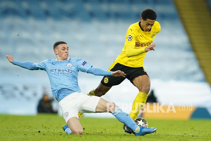 Pemain Manchester City Phil Foden berebut bola dengan  pemain Dortmund Jude Bellingham.