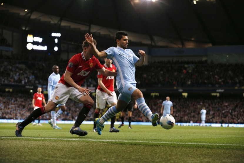 Pemain Manchester City, Sergio Aguero (kanan) berebut bola dengan pemain Manchester United, Phil Jones dalam Derby Manchester, Senin (30/4) 2012 di Etihad Stadium. 