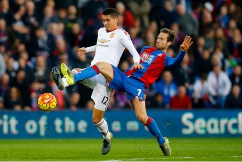 Pemain Manchester United Chris Smalling (putih) berebut bola dengan gelandang Crystal Palace Yohan Cabaye.