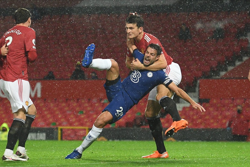 Pemain Manchester United Harry Maguire berebut bola dengan Cesar Azpilicueta saat pertandingan MU melawan Chelsea di Old Trafford