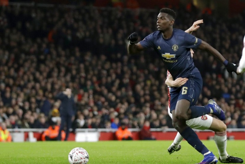 Pemain Manchester United Paul Pogba (kiri) beradu bola dengan pemain Arsenal Granit Xhaka dalam Piala FA di Stadium Emirates, Sabtu (16/1) dini hari.