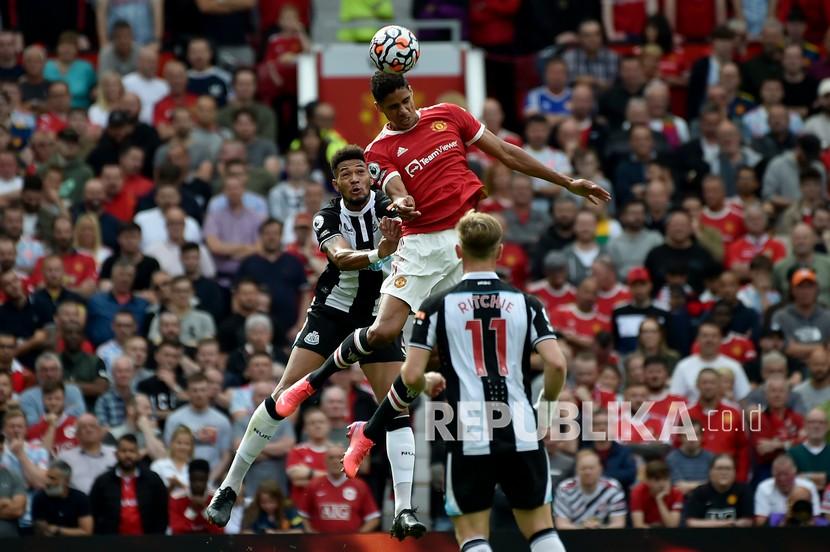  Pemain Manchester United Raphael Varane melompat untuk merebut bola dengan pemain Newcastle Joelinton, kiri, pada pertandingan sepak bola Liga Inggris. (ilustrasi)