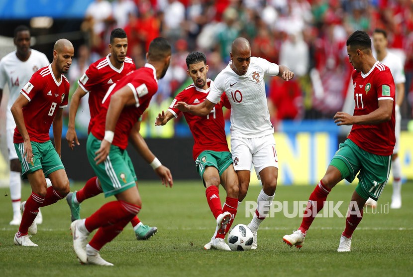 Pemain Maroko mencoba untuk menghentikan pemain Portugal Joao Mario pada  pertandingan grup B Piala Dunai antara Portugal dan Maroko  di Stadion Luzhniki di Moskow, Rusia,  Rabu (20/6).