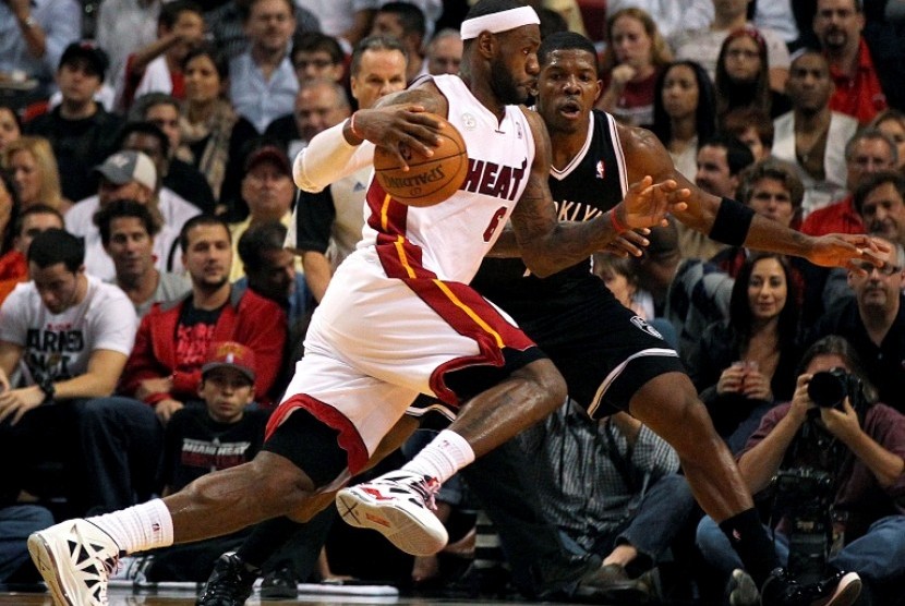 Pemain Miami Heat LeBron James berusaha melewati pemain Brooklyn Nets Joe Johnson dalam pertandingan NBA Rabu (7/11) di Miami