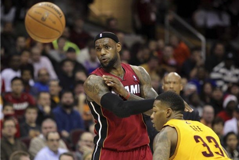 Pemain Miami Heat, LeBron James (kiri), melepaskan operan melewat defender Cleveland Cavaliers, Alonzo Gee, dalam laga NBA di Cleveland pada Rabu (20/3). 