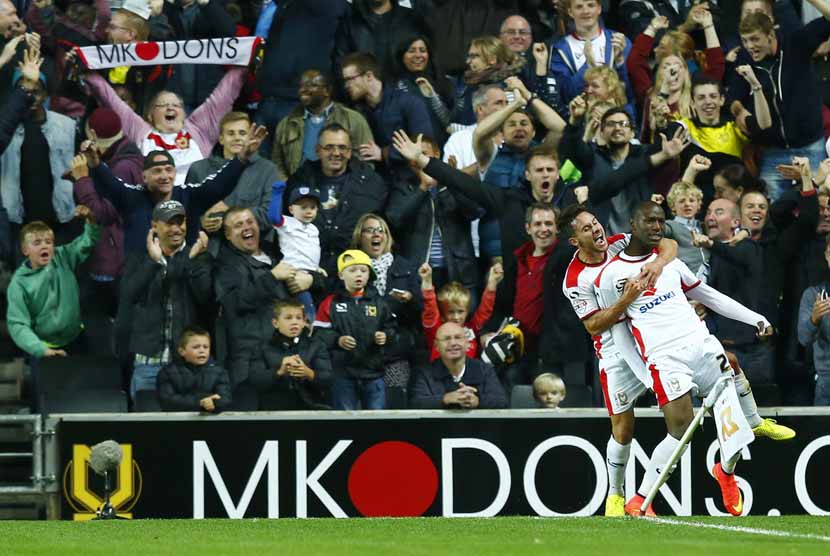 Pemain Milton Keynes Dons, Benik Afobe, melakukan selebrasi golnya usai menjebol gawang Manchester United di laga Piala Liga Inggris di Stadion MK, Milton Keynes, London, Selasa (26/8).