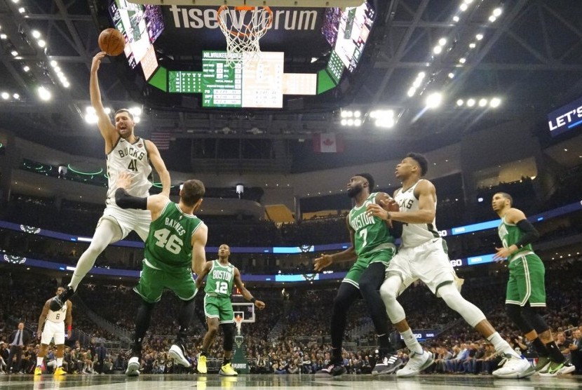 Pemain Milwaukee Bucks, Nikola Mirotic, melakukan lay up diadang pemain Boston Celtics pada play-off NBA di Milwaukee. 