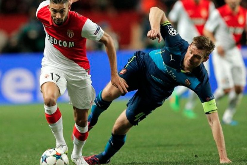 Pemain Monaco Yannick Ferreira-Carrasco,( kiri), melewati  pemain Arsenal Per Mertesacker  dalam lanjutan 16 besar Liga Champions  leg-2 di stadion Louis II di Monaco, Selasa, 17 Maret, 2015.