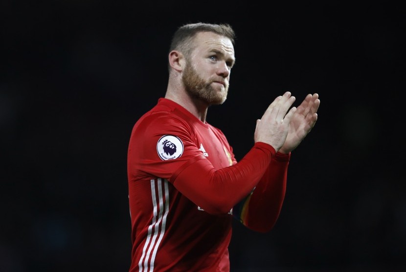 Pemain MU Wayney Rooney bertepuk tangan usai pertandingan melawan West Ham di Old Trafford, Senin (28/11).