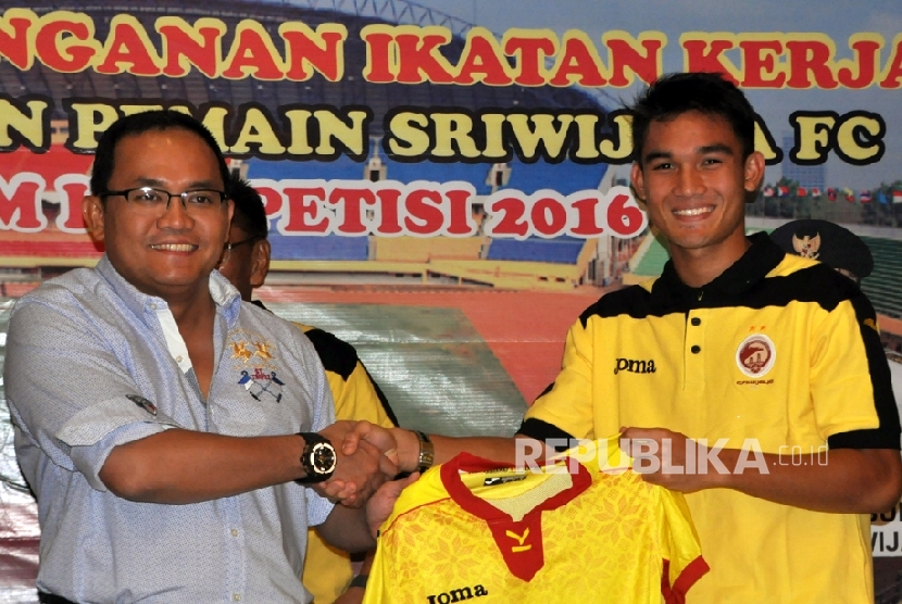 Pemain muda asal Sriwijaya FC U-21 Zalnando bersama Presiden Sriwijaya FC Dodi Reza Alex memegang kostum tim berjuluk Laskar Wong Kito. (Republika/Maspril Aries)