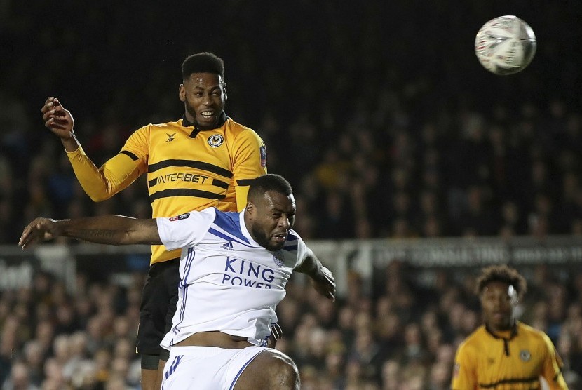 Pemain Newport County, Jamille Matt (kiri), berebut bola dalam duel udara dengan pemain Leicester City dalam laga Piala FA di Stadion Rodney Parade, Newport, Inggris, Ahad (6/1).