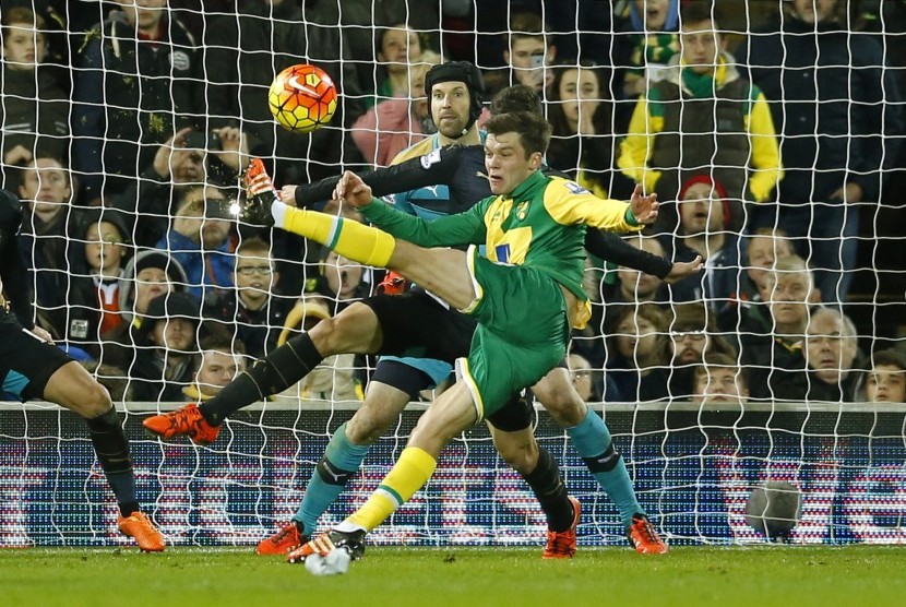 Pemain Norwich Jonathan Howson menendang bola saat melawan Arsenal, Ahad (30/11) waktu setempat. 