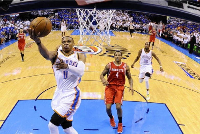 Pemain Oklahoma City Thunder, Russell Westbrook (kiri), menjaringkan bola dalam laga NBA. 