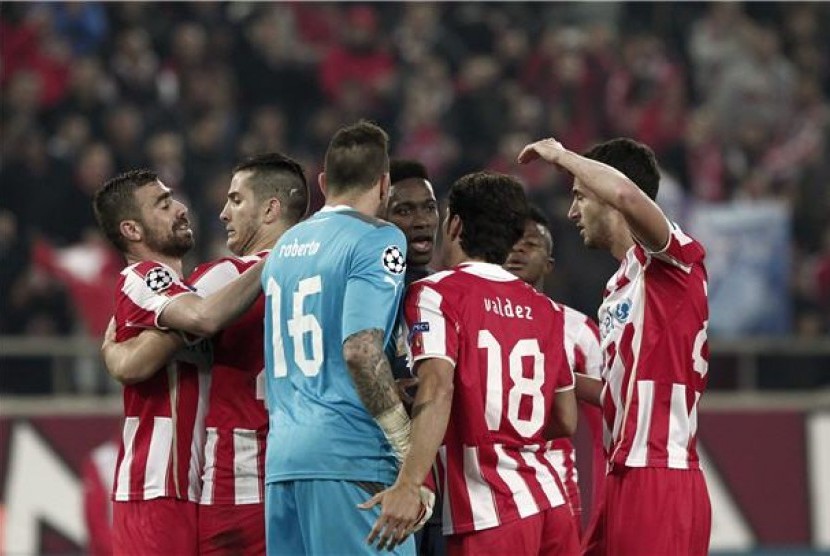  Pemain Olympiakos Piraues merayakan kemenangan mereka 2-0 atas Manchester United di leg pertama babak 16 besar Liga Champions di Stadion Karaiskaki, Athena, Yunani, Selasa (25/2). 