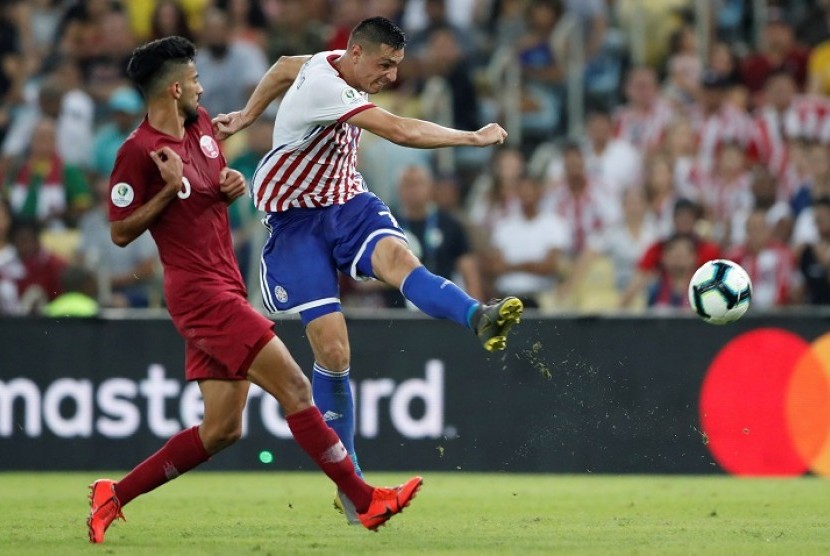  Pemain Paraguay Oscar Cardozo menendang bola dijaga pemain Qatar Tarek Salman pada laga Grup B Copa America 2019 di Stadion Maracana, Rio de Janeiro, Brasil, Senin (17/6) dini hari WIB.