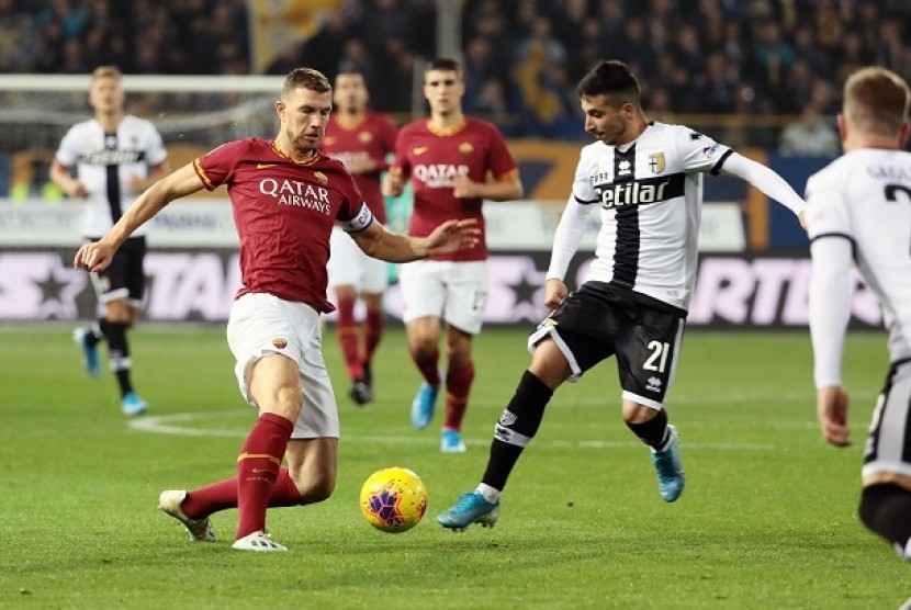 Pemain Parma Matteo Scozzarella (kanan) berebut bola dengan pemain Roma  Edin Dzeko dalam pertandingan pekan ke-12 Serie A Italia di Stadion Ennio Tardini, Ahad (10/11) malam WIB.