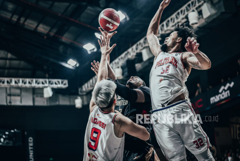 Pemain Pelita Jaya KJ McDaniels (kanan) dan rekannya Agassi Goantara (kiri) berusaha mengadang Jordan Adams dari Dewa United pada game 1 final IBL 2025 di Dewa United Arena, Banten, Kamis (17/7/2025) malam WIB. Pelita Jaya mengalahkan tuan rumah Dewa United Banten 94-77.