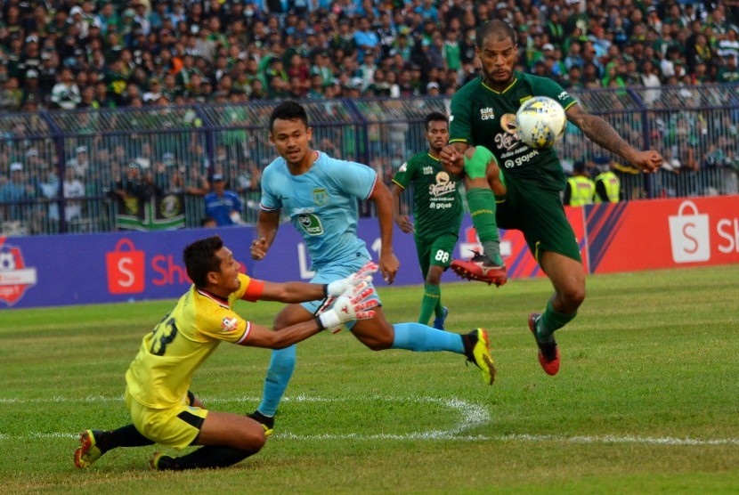 Pemain Persebaya Surabaya, David Aparecido Da Silva (kanan) berusaha melewati kiper Persela, Dwi Kuswanto (kanan) dan Arif Satria (tengah) dalam pertandingan Liga 1 2019 di Stadion Surajaya Lamongan, Jawa Timur, Rabu (23/10/2019).