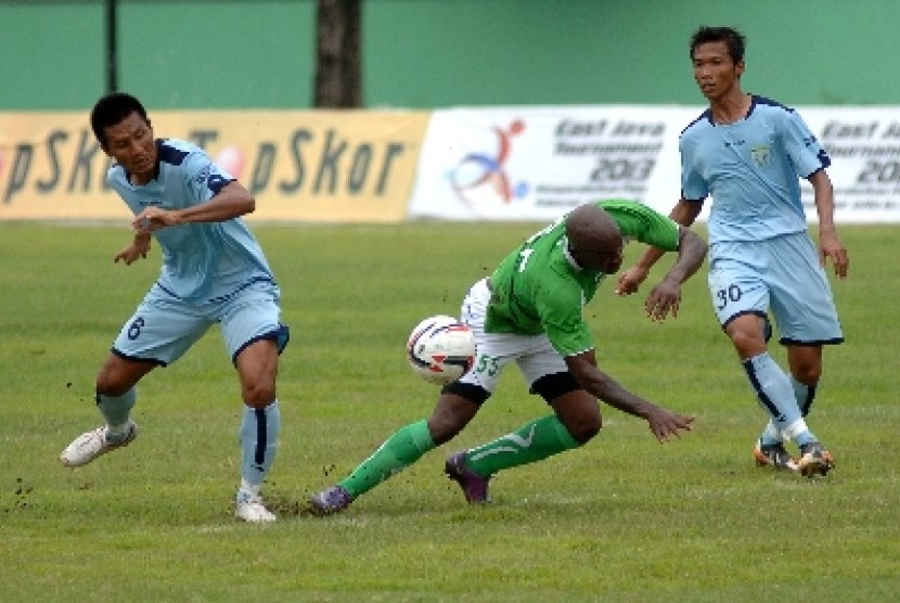 Pemain Persela Lamongan, Suroso (kiri) berebut bola dengan pemain Emmanuel 'Pacho' Kenmogne.