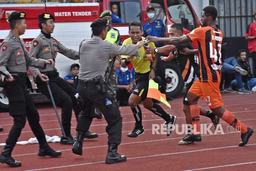 Pemain Perseru Serui Dony Harold Monim (kanan) mengejar asisten wasit Tri Wahyudi (ketiga kanan) untuk memprotes keras dalam pertandingan melawan PSIS Semarang saat pertandingan lanjutan Liga 1 Indonesia di Stadion Moch. Soebroto, Magelang, Jawa Tengah, Ahad (23/9).