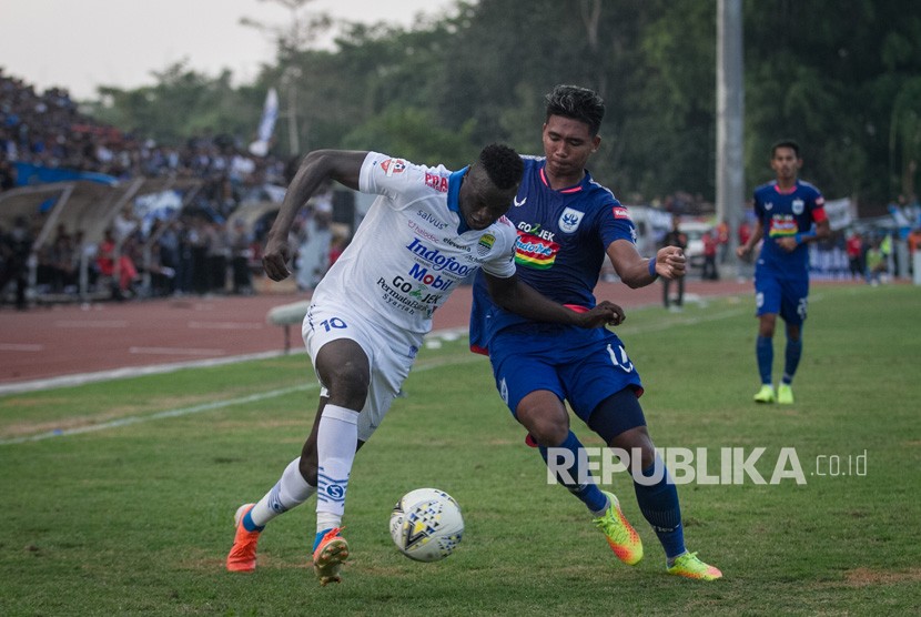 Pemain Persib Bandung Ezechiel Ndouasel (kiri) berebut bola dengan pemain PSIS Semarang Rio Saputro pada pertandingan lanjutan Liga 1 di Stadion Moch. Soebroto, Magelang, Jawa Tengah, Ahad (21/7/2019).