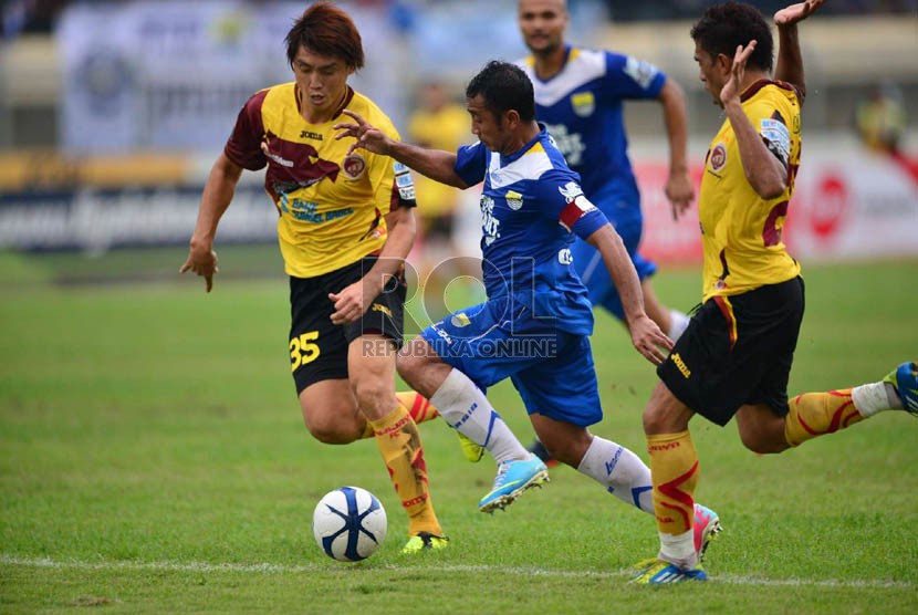  Pemain Persib Bandung Firman Utina dikepung pemain Sriwijaya FC, Herman Dzumafo  dalam pertandingan Liga Super Indonesia 2013 di Stadion Si Jalak Harupat, Bandung, Sabtu (15/6).  (Republika/Yogi Ardhi) 
