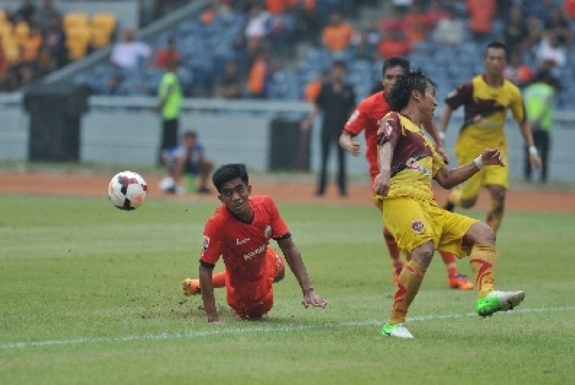 Pemain Persija Jakarta Agung Supriyanto (kiri) berjibaku dengan pemain Sriwijaya FC Asri Akbar (kanan).