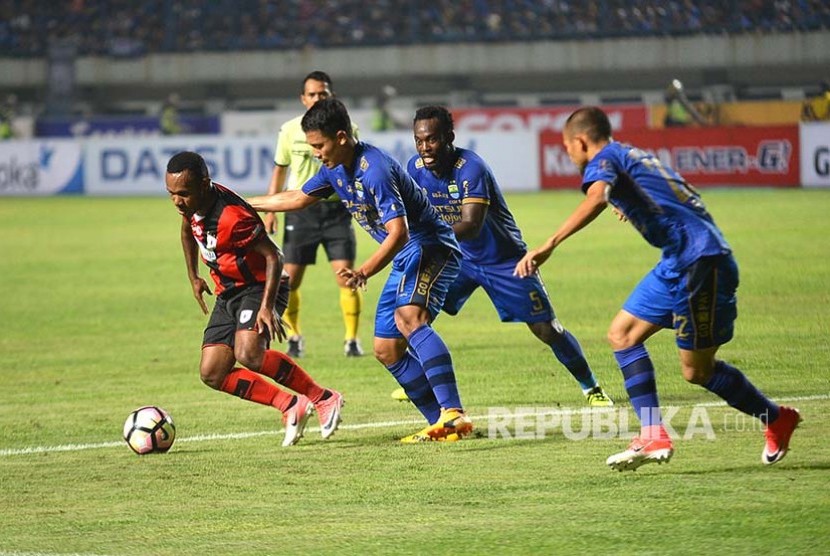 Tiga pemain Persib Bandung (biru) saat menghadapi Persipura.