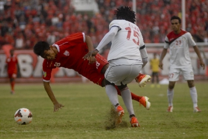 Pemain Persis Solo Dedi Cahyo Putro dijegal (kiri) dijegal Elad Hendri Njobi dari Martapura FC Kalsel.