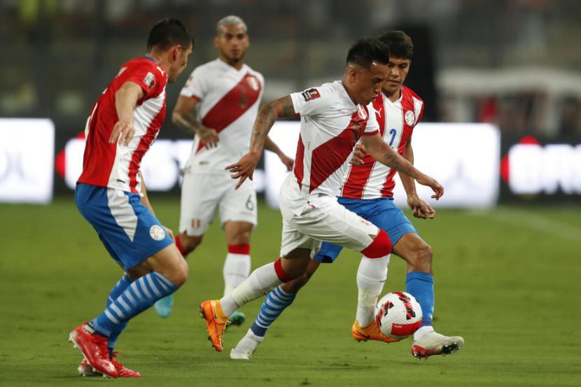 Pemain Peru Christian Cueva (tengah) menggiring bola dijaga para pemain Paraguay dalam laga kualifikasi Piala Dunia 2022 Zona Conmebol, Rabu (30/3/2022). Peru menang 2-0 dan akan menjalani playoff melawan wakil Asia.