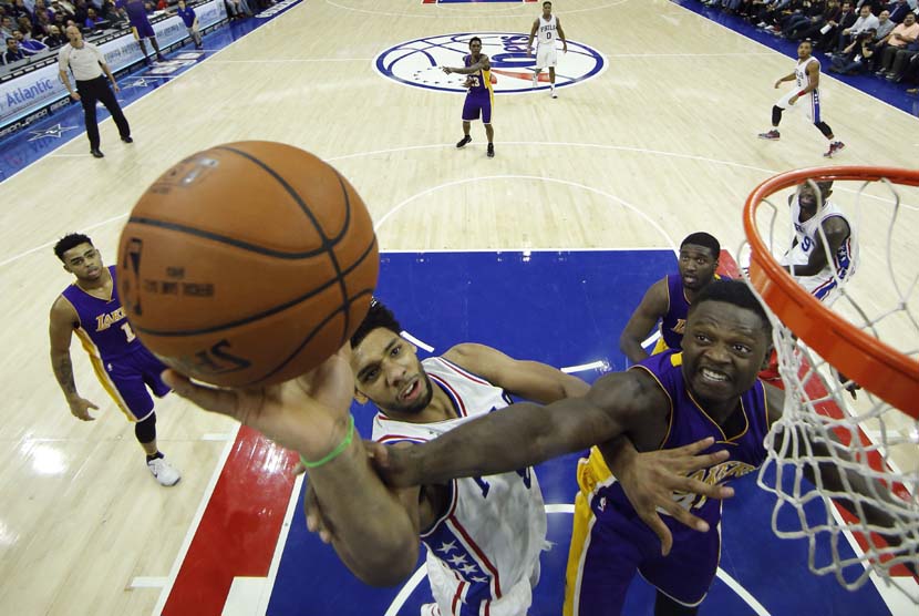 Pemain Philadelphia 76ers, Jahlil Okafor (kiri), berusaha menjaringkan bola di bawah kawalan pemain Los Angeles Lakers, Julius Randle, dalam laga basket NBA di Philadelphia pada Selasa (1/12). 