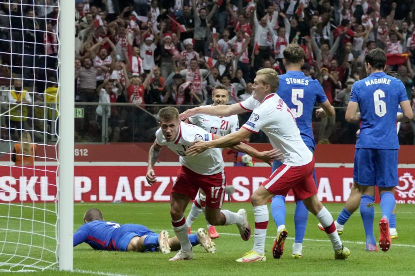 Pemain Polandia Damian Szymanski (kiri), mencetak gol pertama timnya selama pertandingan sepak bola kualifikasi grup I Piala Dunia 2022 antara Polandia dan Inggris, di Stadion Narodowy di Warsawa, Polandia, Rabu, 8 September 2021.
