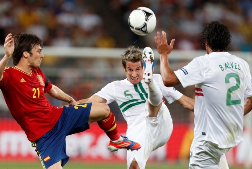 Pemain Portugal Fabio Coentrao (tengah) menendang bola dengan kawalan David Silva (kiri) dalam babak semifinal Piala Eropa 2012 yang mempertemukan Spanyol melawan Portugal, Kamis (28) WIB dinihari. 