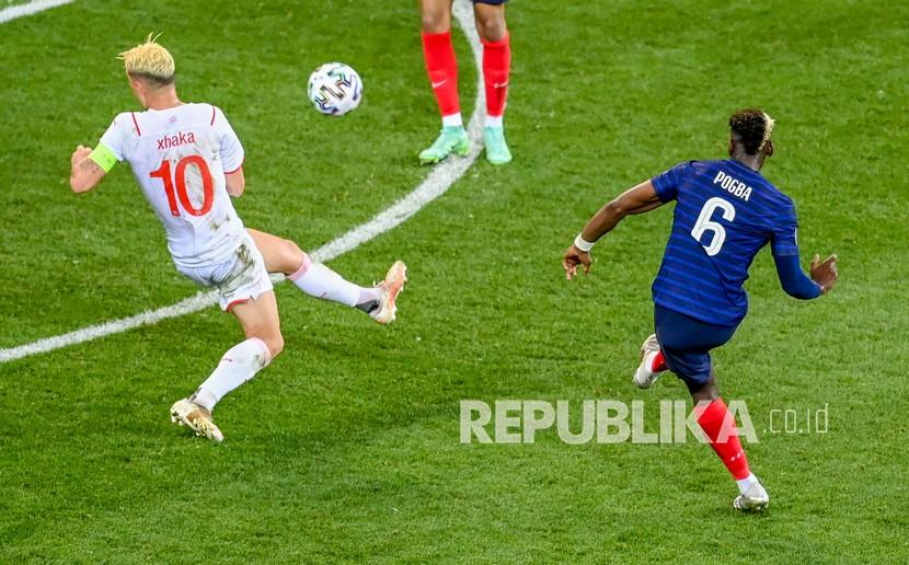 Pemain Prancis Paul Pogba, kanan, menendang bola melewati pemain Swiss Granit Xhaka untuk mencetak gol ketiga timnya pada pertandingan babak 16 besar Piala Eropa 2020 antara Prancis dan Swiss di Stadion National Arena, Bucharest, Rumania, Selasa (29/6) dini hari WIB.