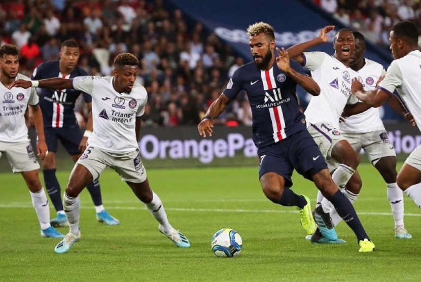 Pemain PSG Eric Maxim Choupo-Moting mencoba melewati pemain Toulouse dalam pertandingan Senin (26/8) dini hari