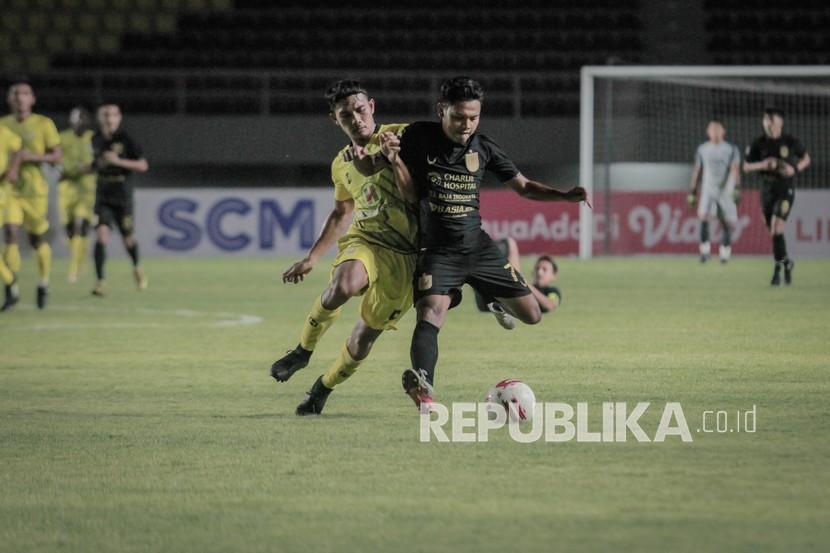 Pemain PSIS Semarang Fandi Eko Utomo (kanan) berebut bola dengan pemain Barito Putra Dandi Maulana Abdulhak (kiri) pada pertandingan Piala Menpora di Stadion Manahan, Solo, Jawa Tengah, Ahad (21/3/2021). 