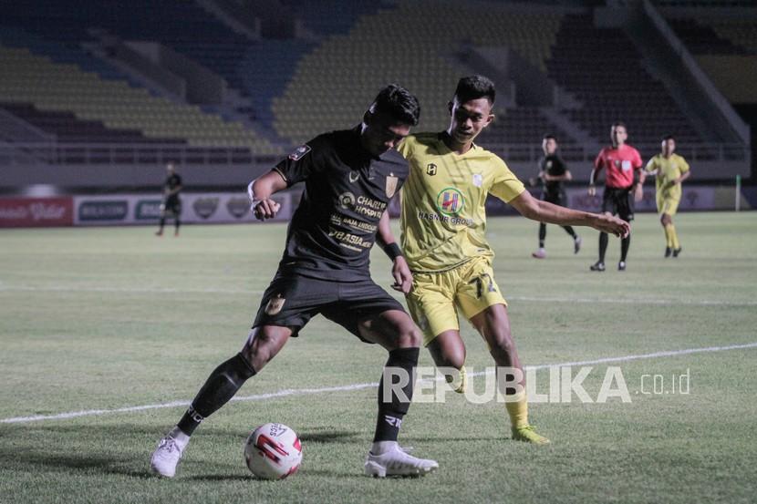 Pemain PSIS Semarang Rio Saputro (kiri) berebut bola dengan pemain Barito Putra Kahar Kalu (kanan) pada pertandingan Piala Menpora di Stadion Manahan, Solo, Jawa Tengah, Ahad (21/3/2021).