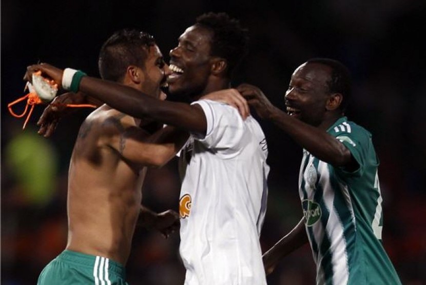 Pemain Raja Casblanca menari dengan jersey dan sepatu miliki Ronaldinho, pemain Atletico Mineiro, usai laga semifinal Piala Dunia Antarklub di Stadion Marrakech, Maroko, Rabu (18/12). 