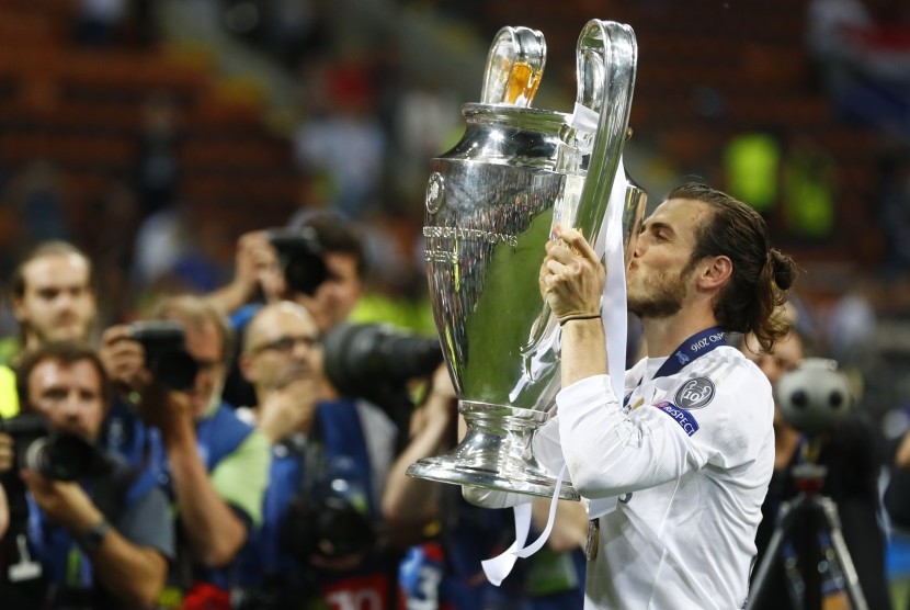 Gareth Bale mengecup trofi Liga Champions saat menjadi juara bersama Real Madrid beberapa waktu lalu.