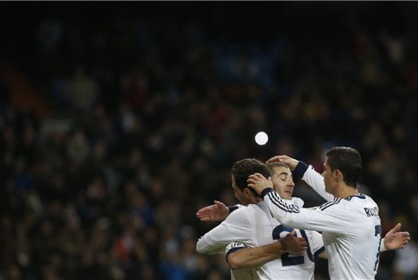 Pemain Real Madrid, Gonzalo Higuain dan Cristiano Ronaldo (kanan), memberikan selamat kepada Karim Benzema (tengah) usai mencetak gol dalam laga La Liga lawan Real Mallorca di Santiago Bernabeu, Madrid, Sabtu (16/3).