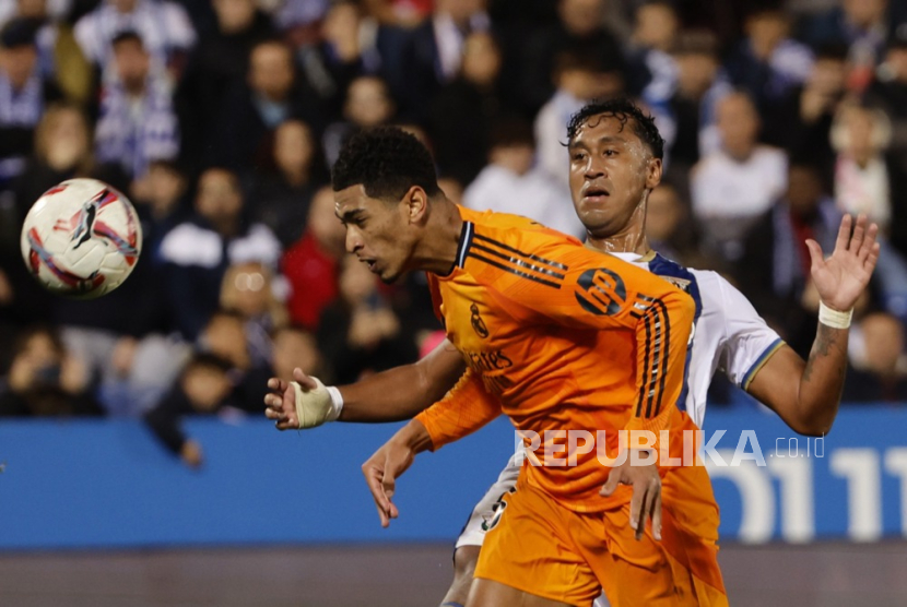 Pemain Real Madrid Jude Bellingham (kiri) berebut bola dengan pemain Leganes Renato Tapia selama pertandingan LaLiga Spanyol antara Leganes dan Real Madrid di Stadion Butarque, di Leganes, Madrid, Spanyol, Senin 25 November 2024. 