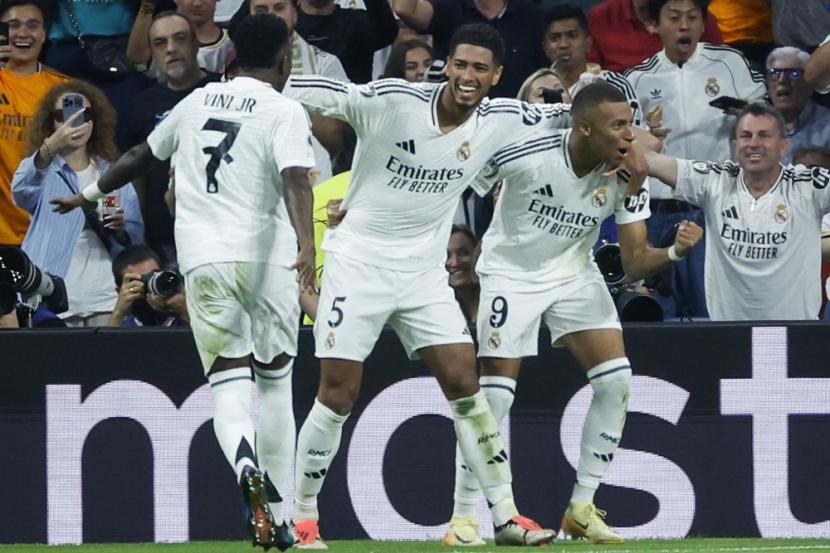 Pemain Real Madrid Kylian Mbappe (kanan) merayakan gol ke gawang Vfb Stuttgart bersama rekan setimnya Vinicius Jr (kiri) dan Jude Bellingham (tengah) dalam pertandingan sepak bola Liga Champions UEFA di Santiago Bernabeu, Madrid, Rabu (18/9/2024) dini hari WIB. 