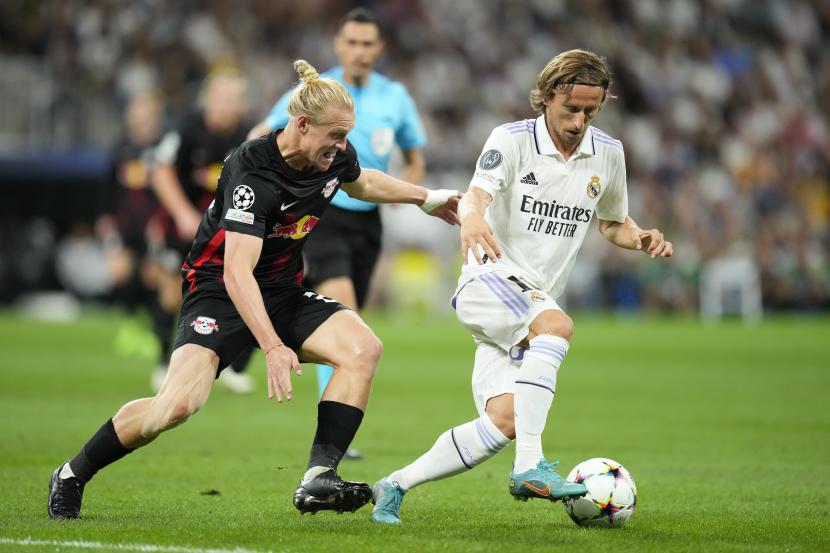 Pemain Real Madrid Luka Modric, berduel memperebutkan bola dengan pemain Leipzig Xaver Schlager pada pertandingan sepak bola grup F Liga Champions antara Real Madrid dan Leipzig di stadion Santiago Bernabeu di Madrid, Rabu, 14 September 2022. 