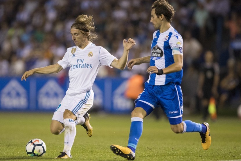 Pemain Real Madrid Luka Modric (kiri) bersama pemain Deportivo Mosquera di pertandingan La Liga Spanyol, Senin (21/8).