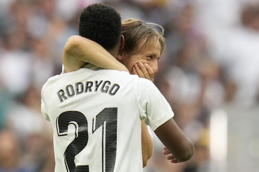 Pemain Real Madrid Luka Modric memeluk rekan setimnya Rodrygo pada akhir pertandingan sepak bola La Liga Spanyol antara Real Madrid dan Barcelona di stadion Santiago Bernabeu di Madrid, Ahad, 16 Oktober 2022.